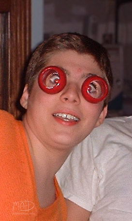 A person is wearing novelty glasses with red spiral frames, giving a humorous and exaggerated appearance.